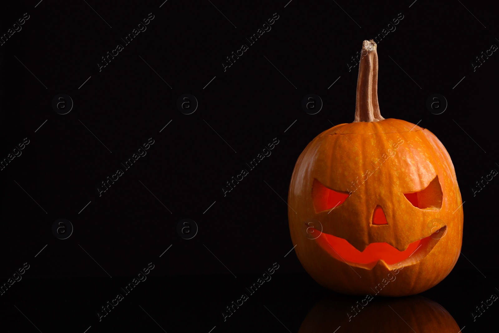 Photo of Pumpkin head on black background, space for text. Jack lantern - traditional Halloween decor