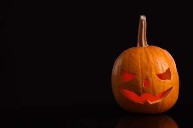 Photo of Pumpkin head on black background, space for text. Jack lantern - traditional Halloween decor