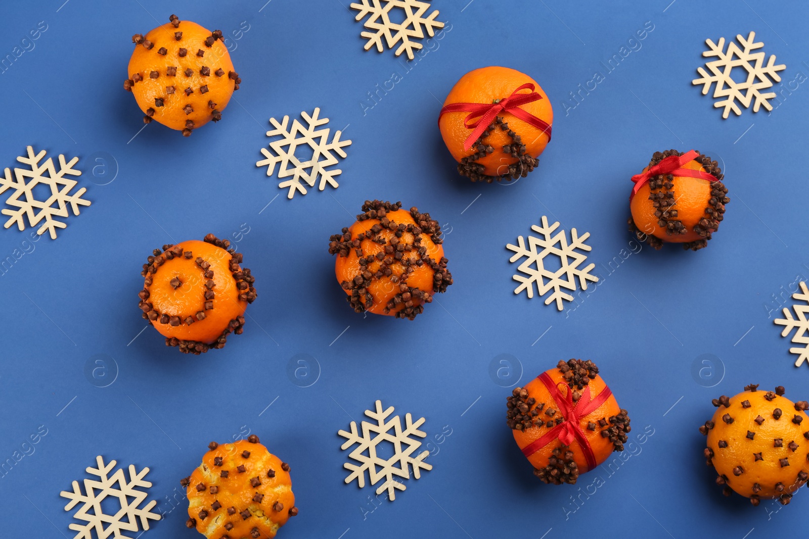 Photo of Flat lay composition with pomander balls made of fresh tangerines on blue background