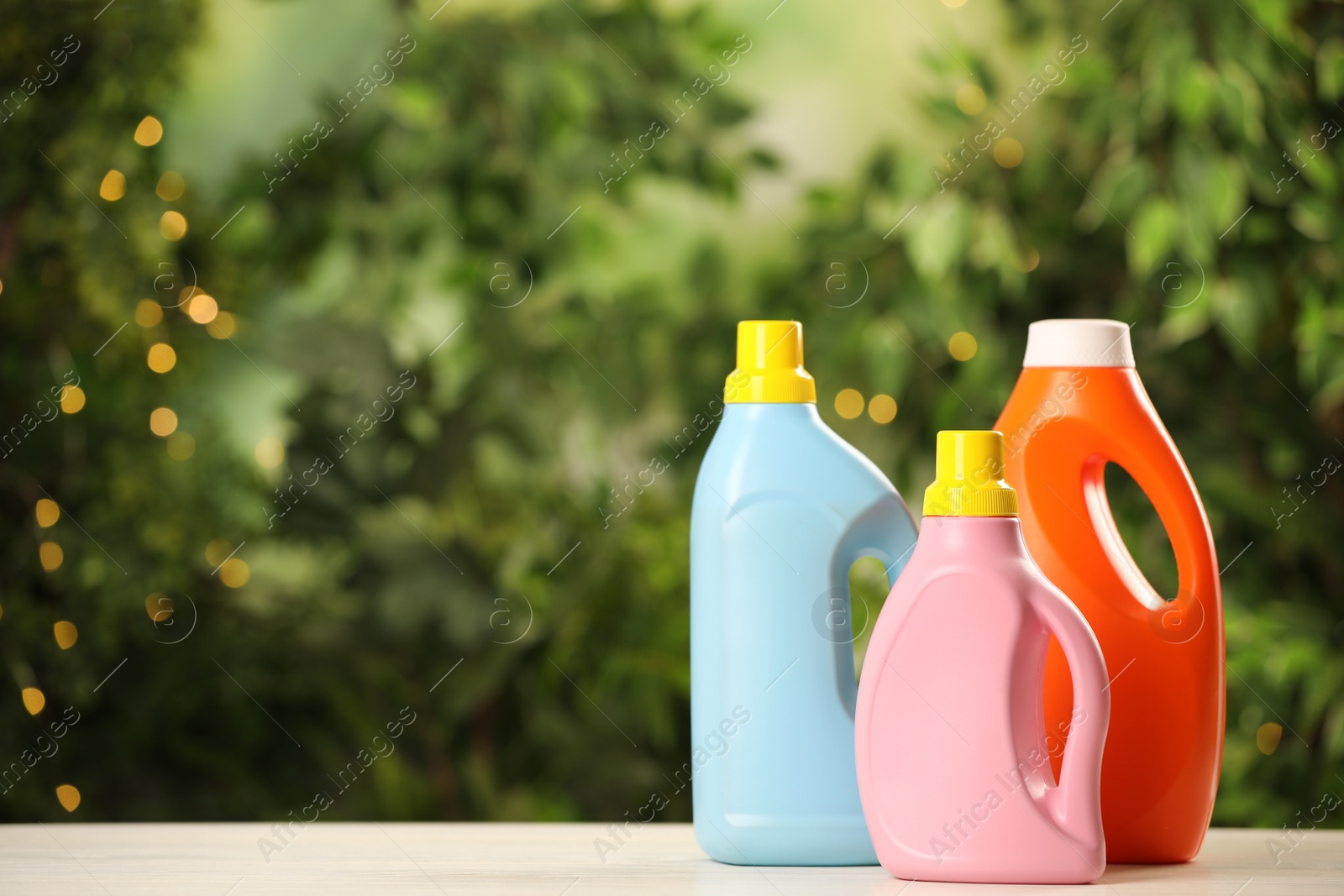 Photo of Different detergents on white wooden table outdoors, space for text. Laundry day