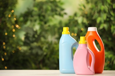 Different detergents on white wooden table outdoors, space for text. Laundry day