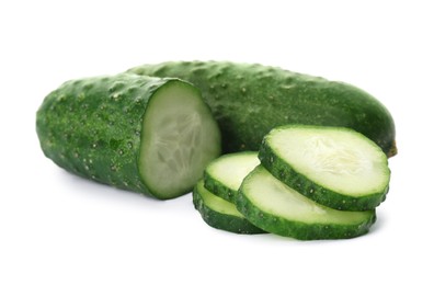 Photo of Whole and cut cucumbers on white background