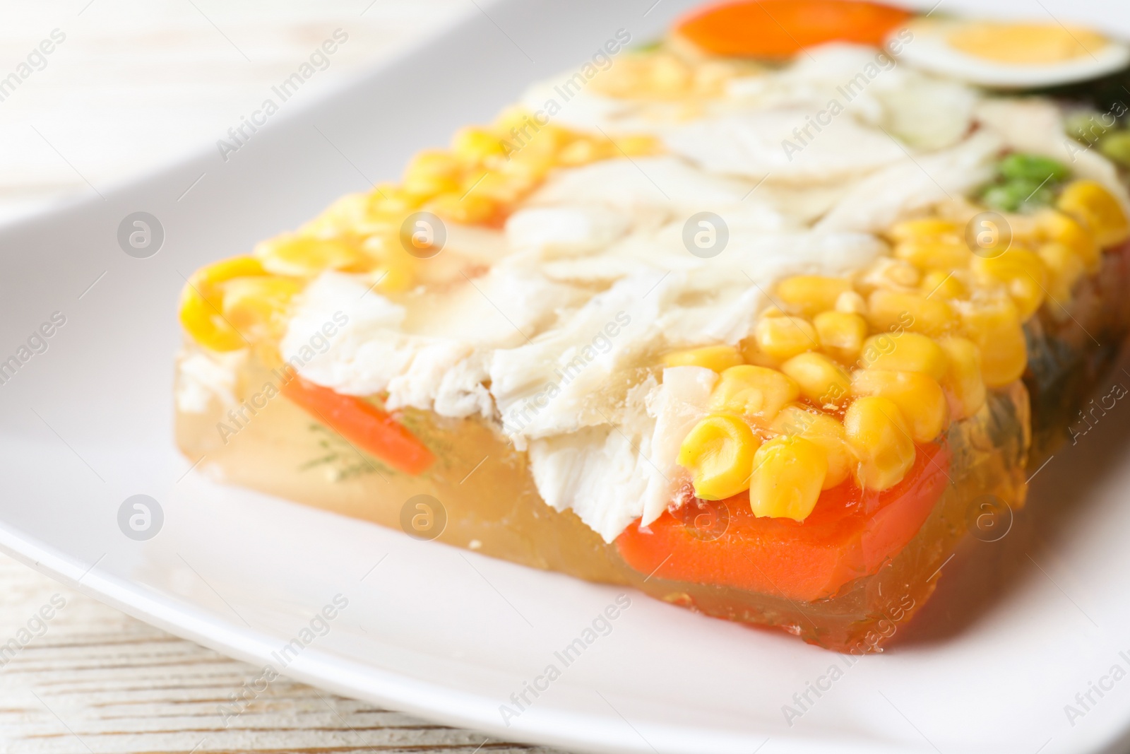 Photo of Delicious fish aspic with vegetables on plate, closeup