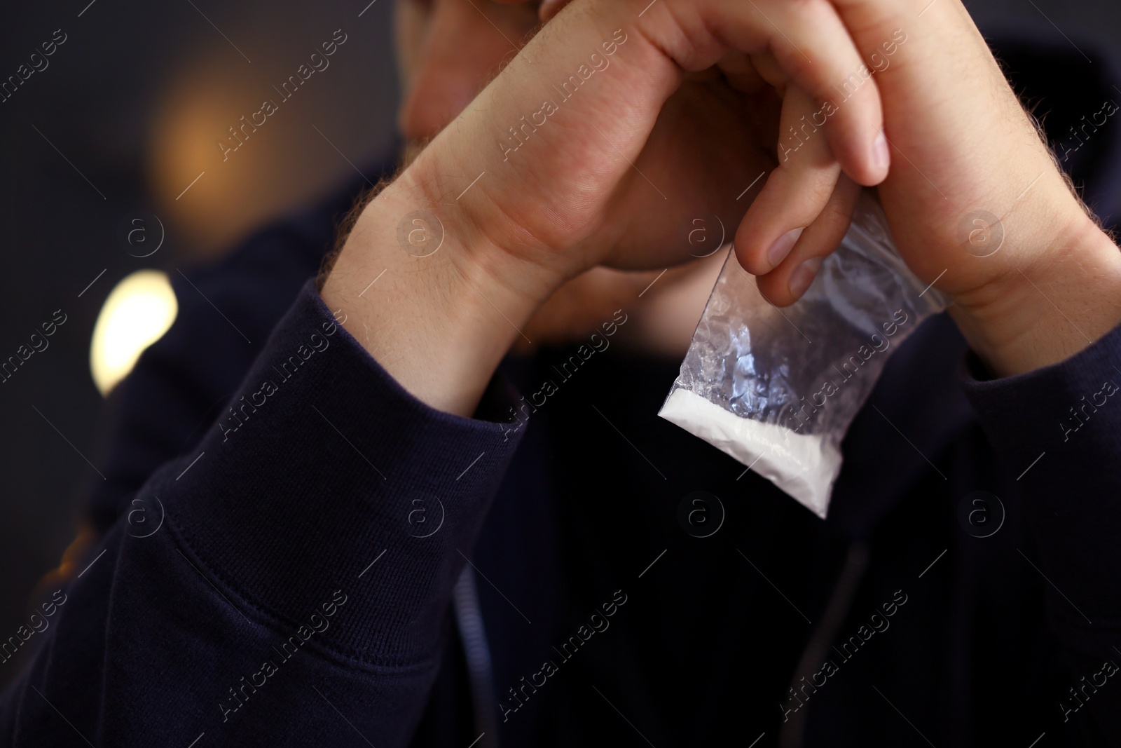 Photo of Criminal holding plastic bag with drug, closeup