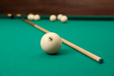 Billiard balls and cue on table indoors