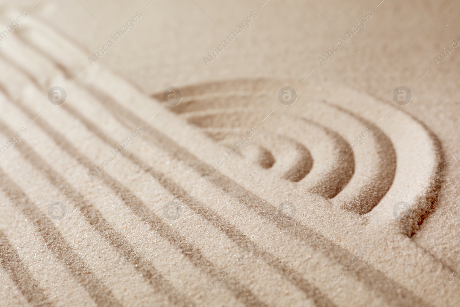 Photo of Zen garden pattern on sand. Meditation and harmony