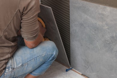 Worker using suction plate for tile installation indoors, closeup