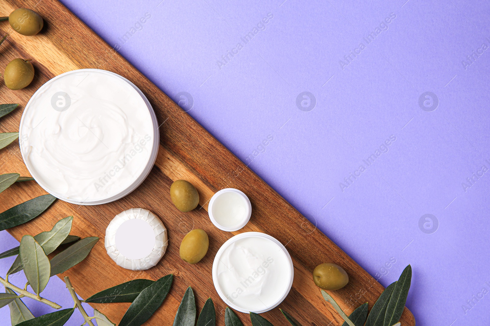 Photo of Different cosmetic products and olives on violet background, top view. Space for text