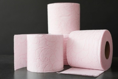 Photo of Soft toilet paper rolls on black background