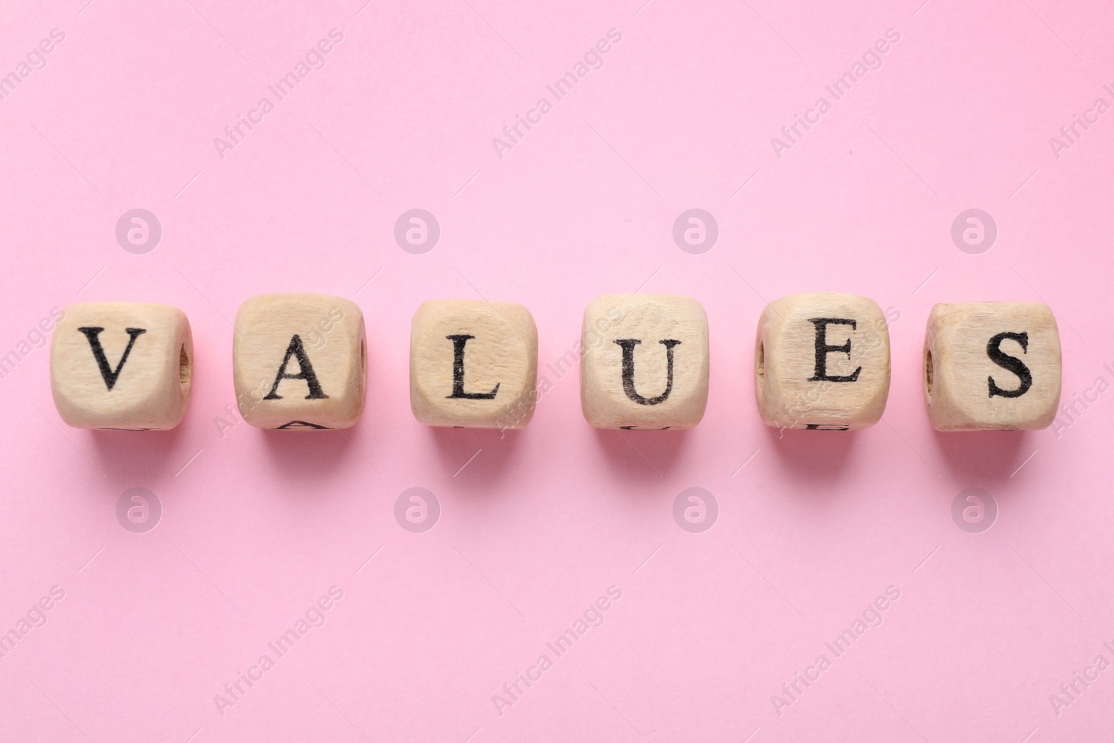 Photo of Beads with word VALUES on pink background, flat lay