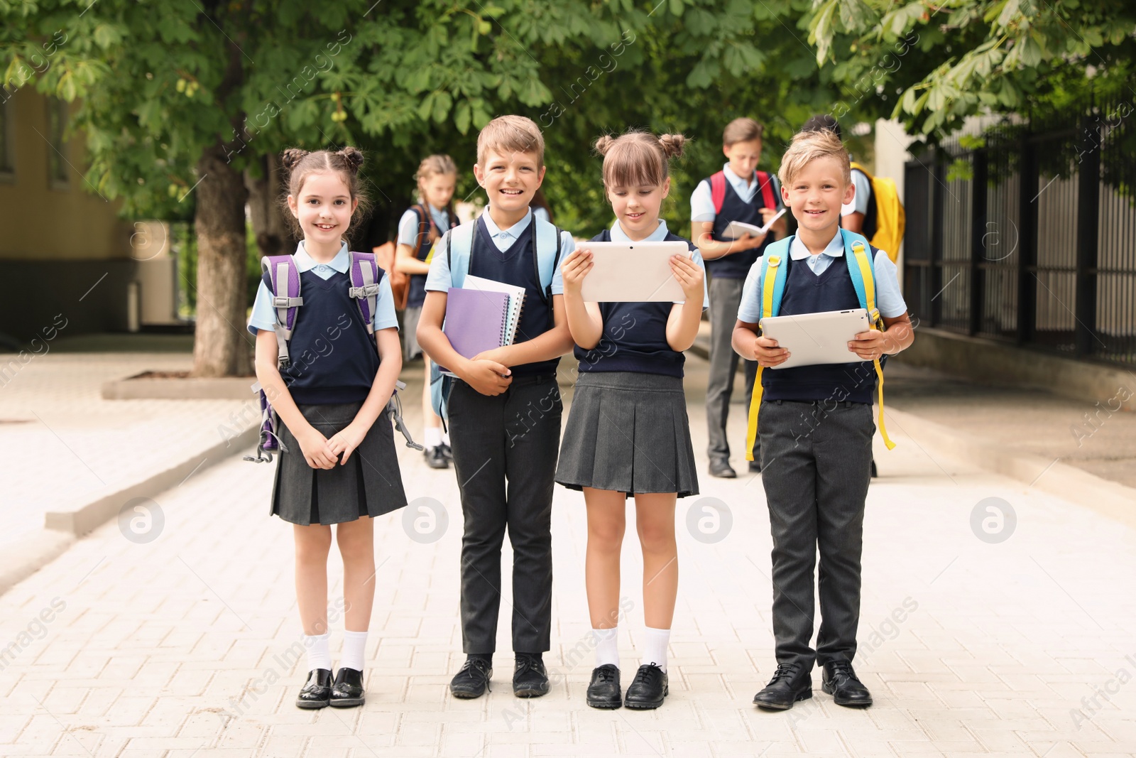 Photo of Little children in stylish school uniform outdoors