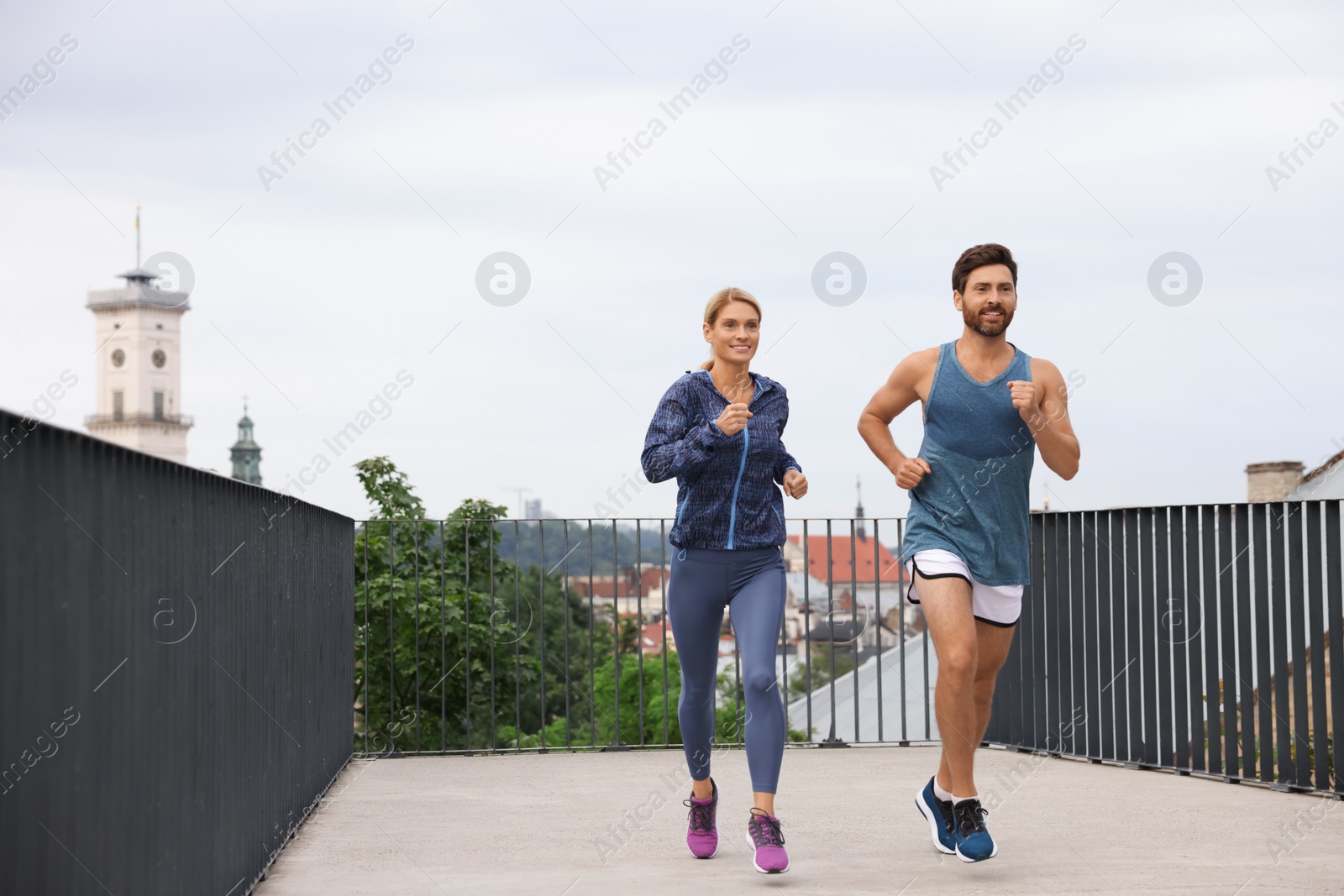 Photo of Healthy lifestyle. Happy sporty couple running outdoors, space for text