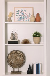 Interior design. Shelves with stylish accessories and books indoors