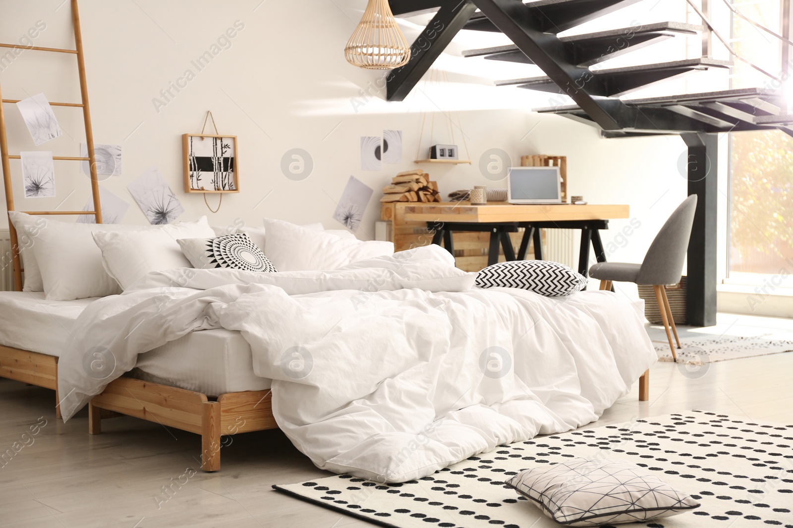 Photo of Elegant interior of bedroom with workplace under stairs