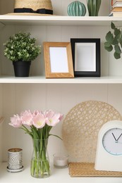 White shelving unit with plants and different decorative stuff