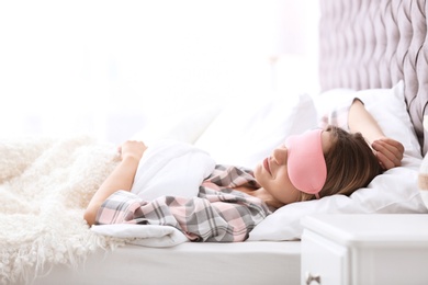 Young beautiful woman with mask sleeping in bed at home. Early morning