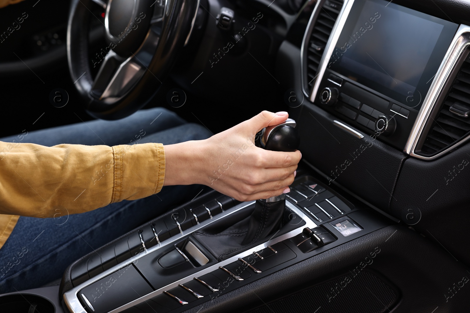 Photo of Woman using gear stick while driving her car, closeup