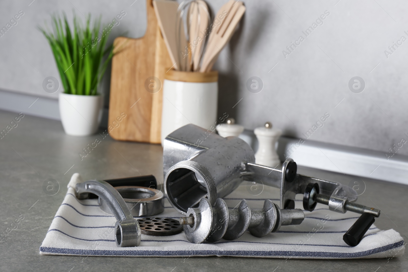Photo of Clean parts of manual meat grinder on grey table indoors