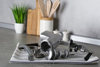 Clean parts of manual meat grinder on grey table indoors