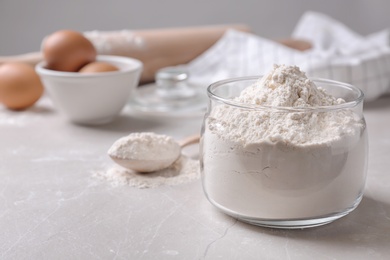 Photo of Glass bowl with flour on table