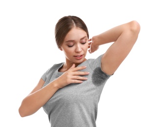 Young woman with sweat stain on her clothes against white background. Using deodorant