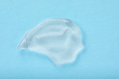 Photo of Smear of ointment on light blue background, top view