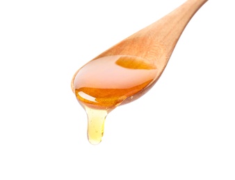 Honey dripping from spoon on white background