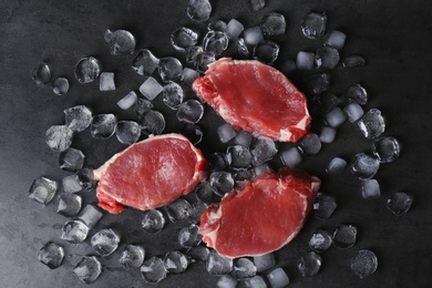 Photo of Flat lay composition with raw meat and ice cubes on dark background