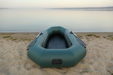 Photo of Inflatable rubber fishing boat on sandy beach near river