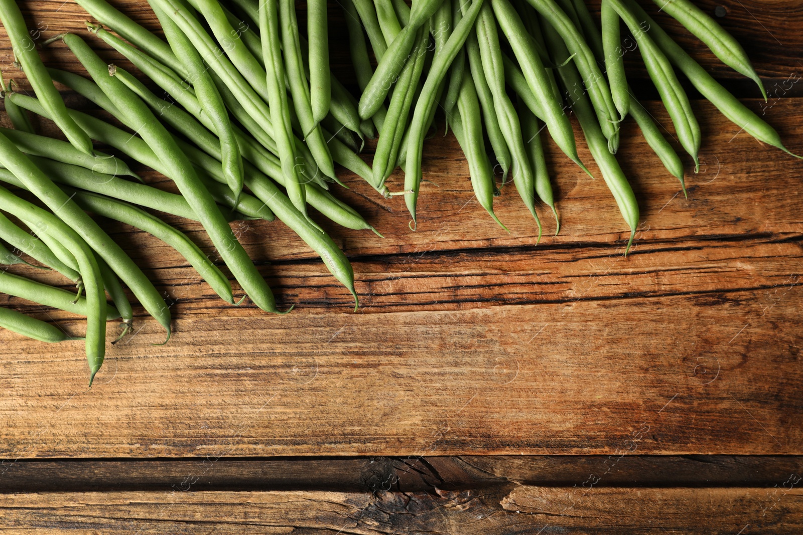 Photo of Fresh green beans on wooden table, flat lay. Space for text