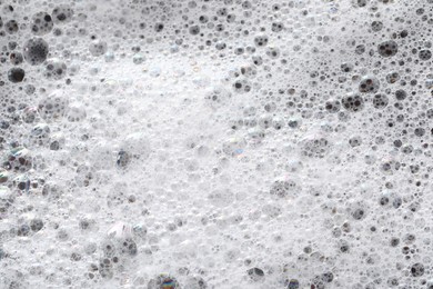 White washing foam on dark gray background, top view