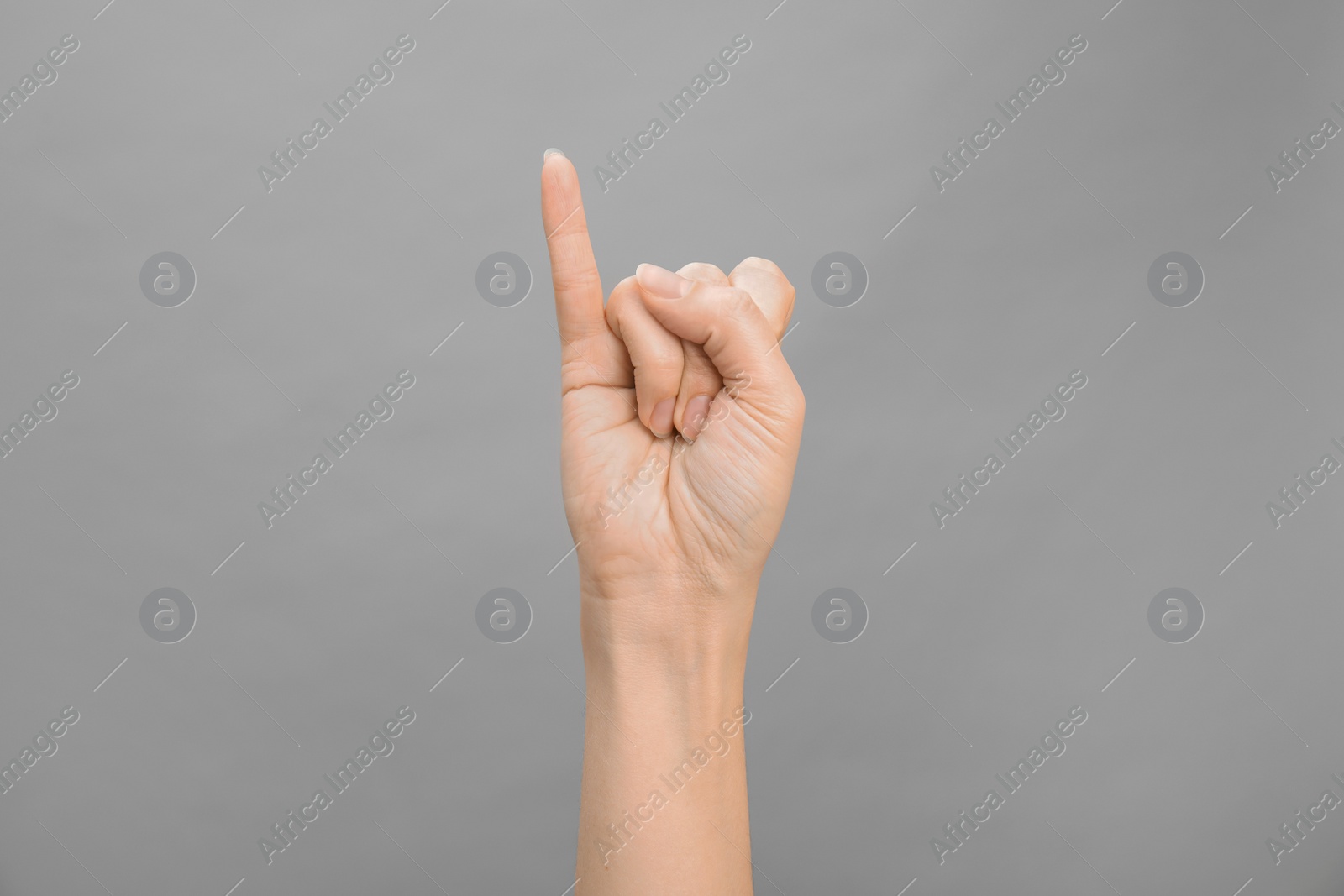 Photo of Woman showing I letter on grey background, closeup. Sign language