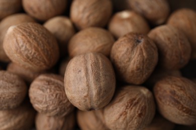 Many whole nutmegs as background, closeup view