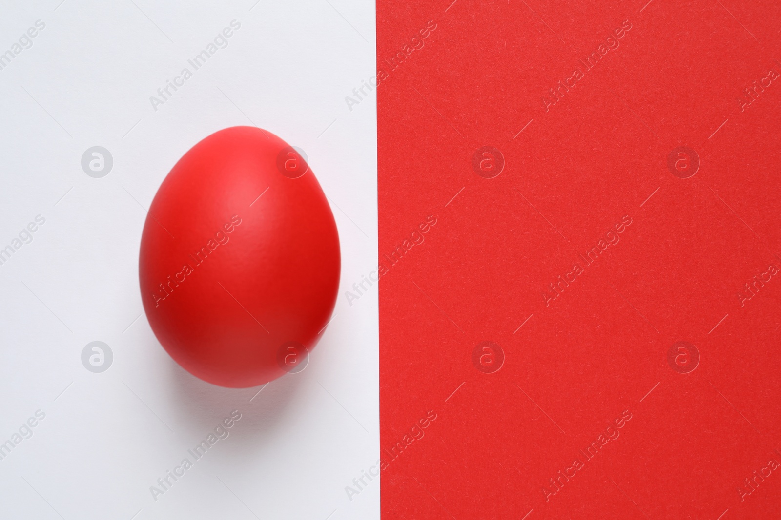 Photo of Red dyed Easter egg on color background, top view. Space for text