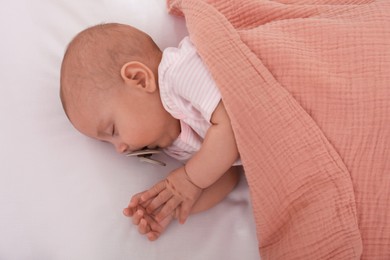 Cute little baby with pacifier sleeping under blanket, top view