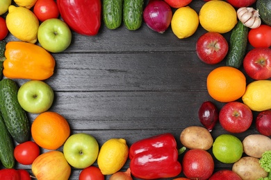 Photo of Frame made of ripe fruits and vegetables on black wooden background, flat lay. Space for text