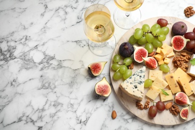 Set of different snacks with ripe figs served on marble table, flat lay. Space for text