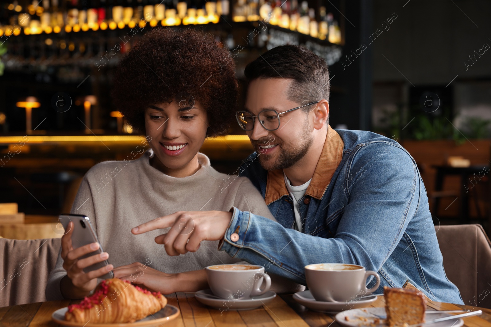 Photo of International dating. Happy couple spending time together in cafe