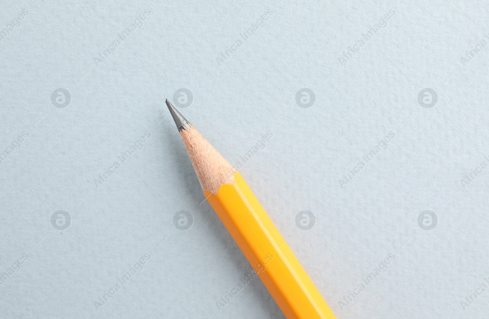 Photo of One sharp graphite pencil on white background, top view