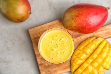 Glass of fresh mango drink and fruits on table, top view