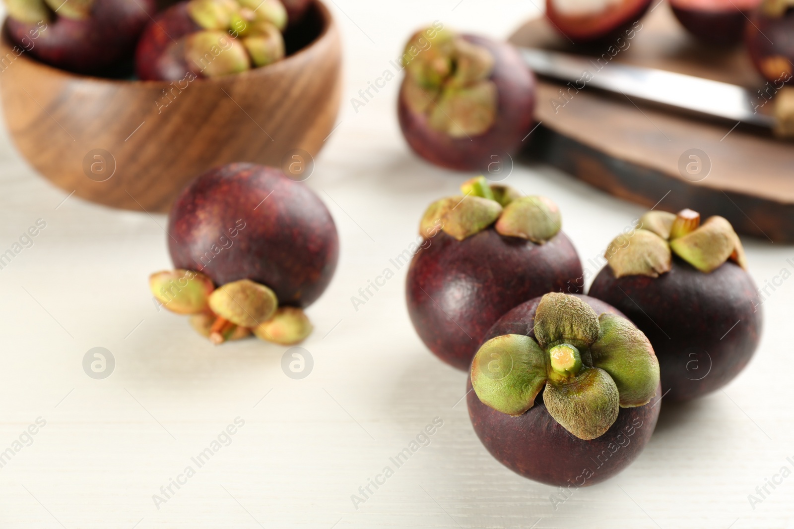 Photo of Fresh ripe mangosteen fruits on white table