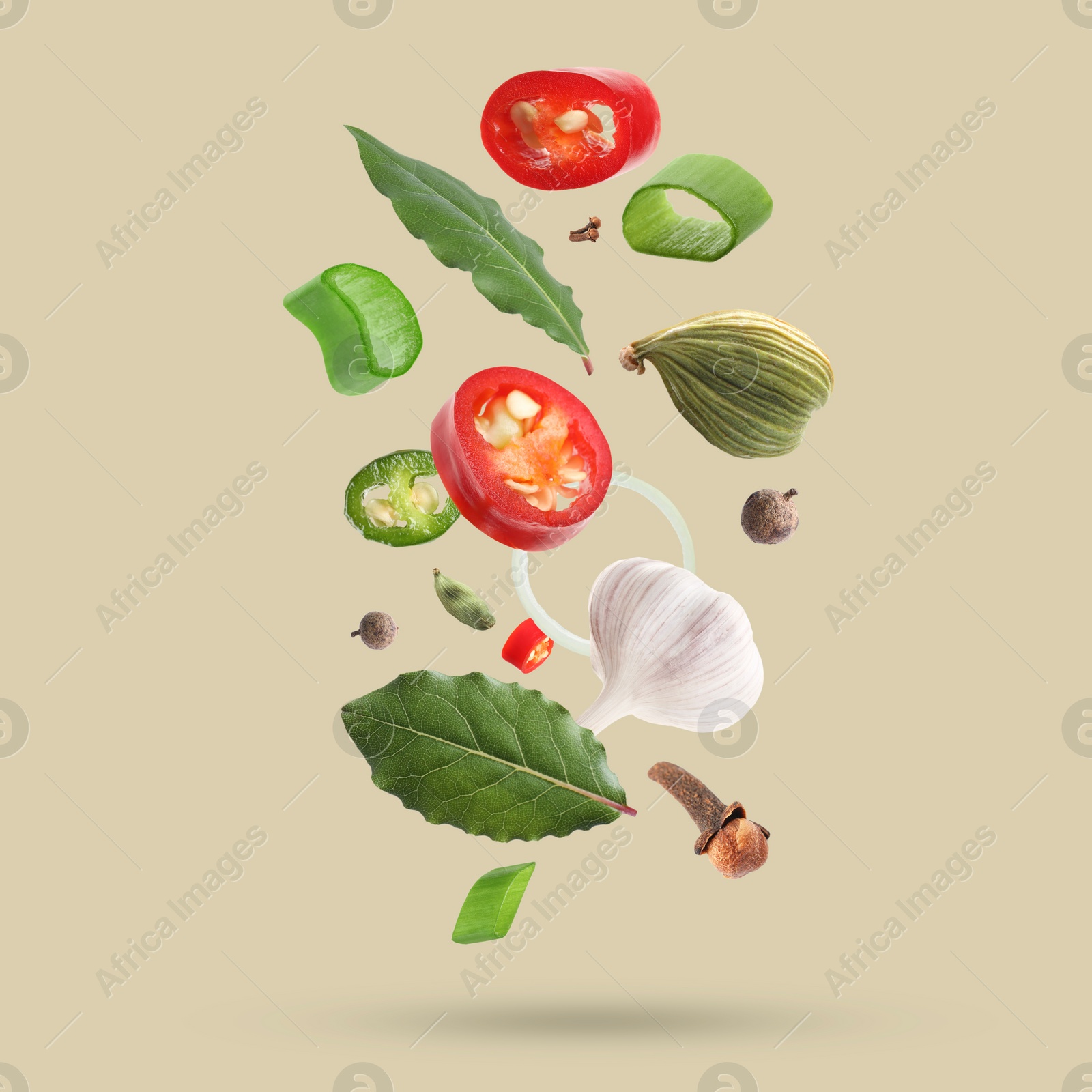 Image of Different spices falling on dark beige background