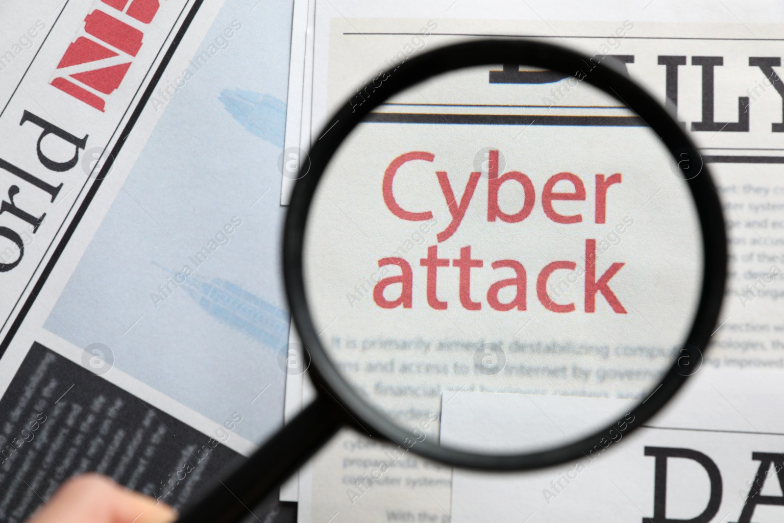 Photo of Newspaper with headline CYBER ATTACK, view through magnifying glass