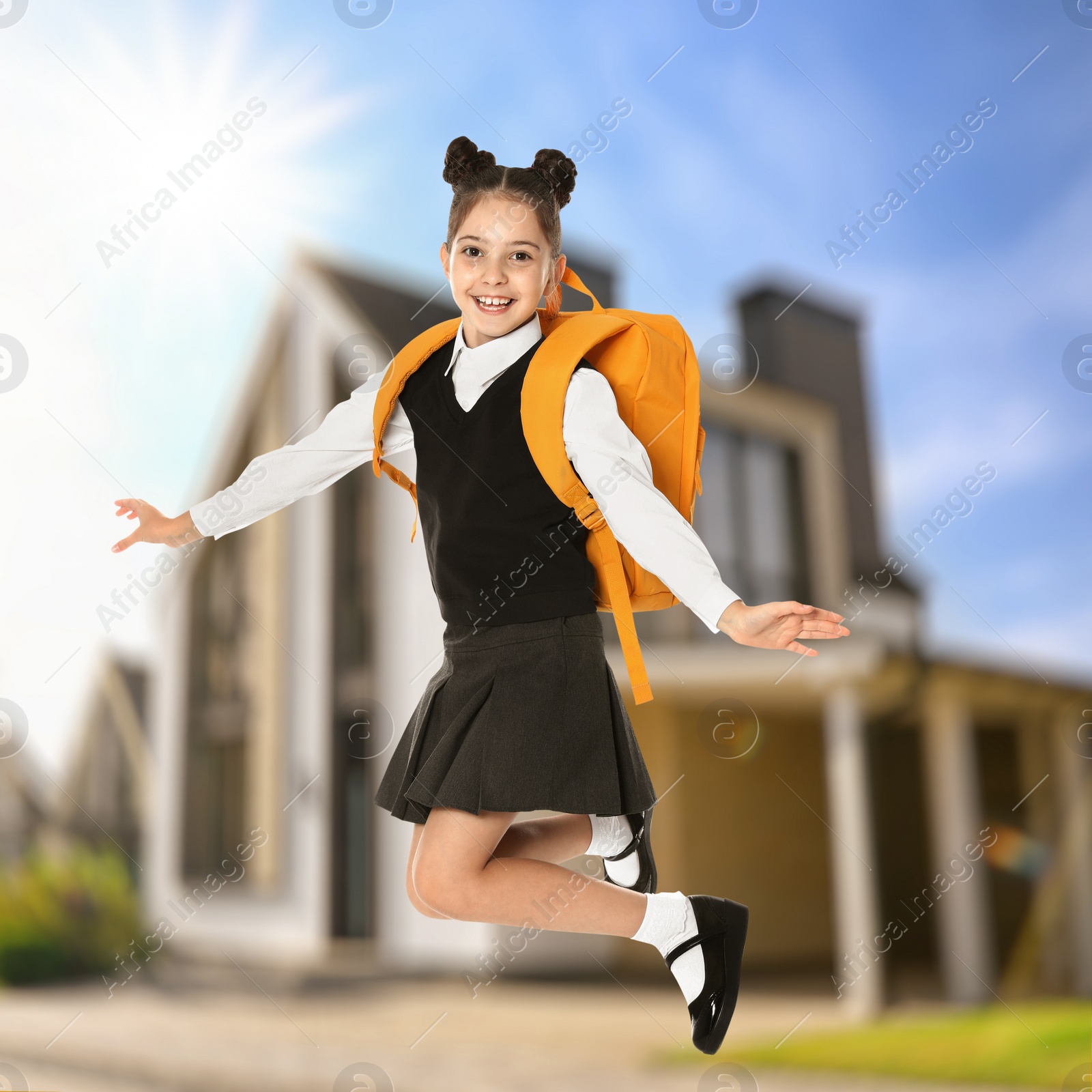 Image of Happy girl jumping near house. School holidays