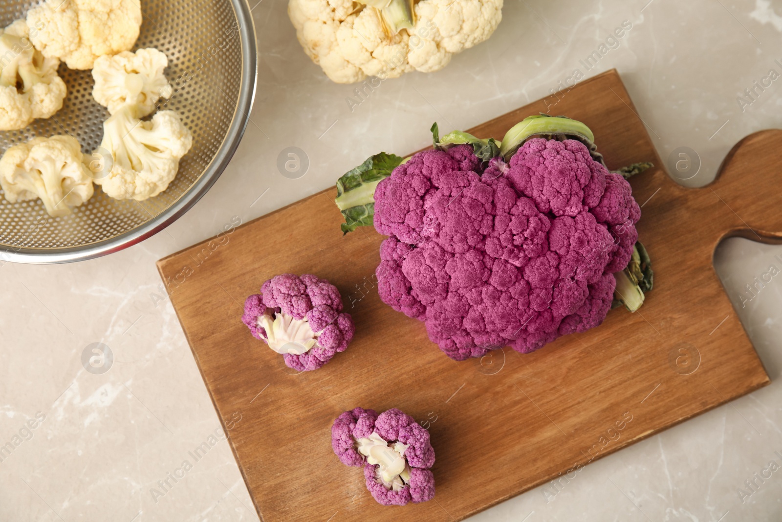 Photo of Wooden board with purple cauliflower cabbage on table, top view. Healthy food