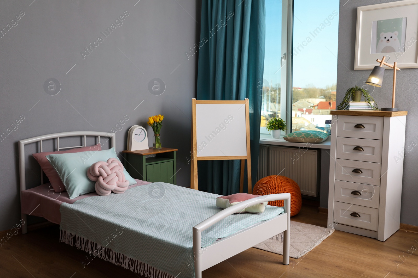 Photo of Stylish child room interior with comfortable bed and board