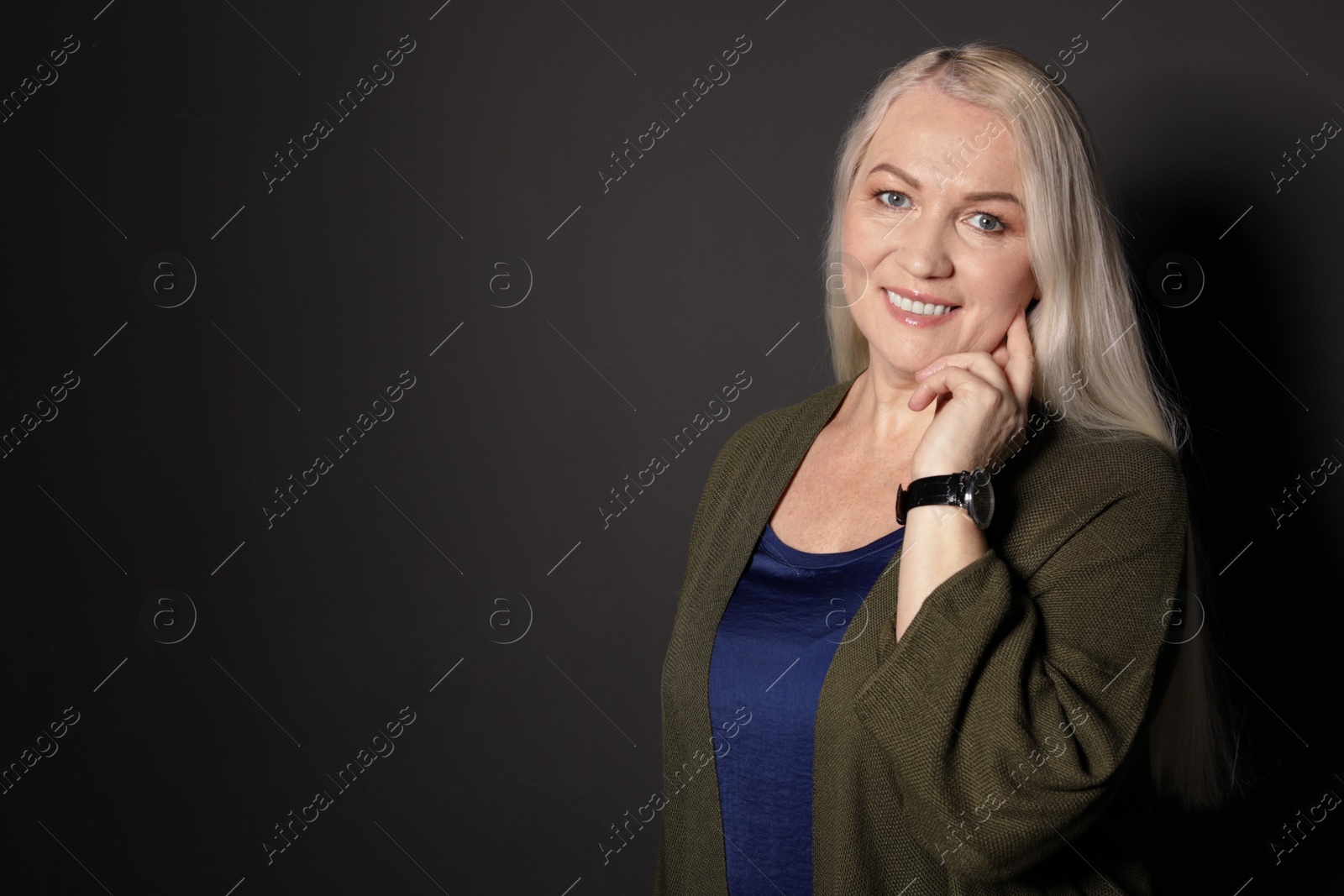 Photo of Portrait of mature woman on black background. Space for text