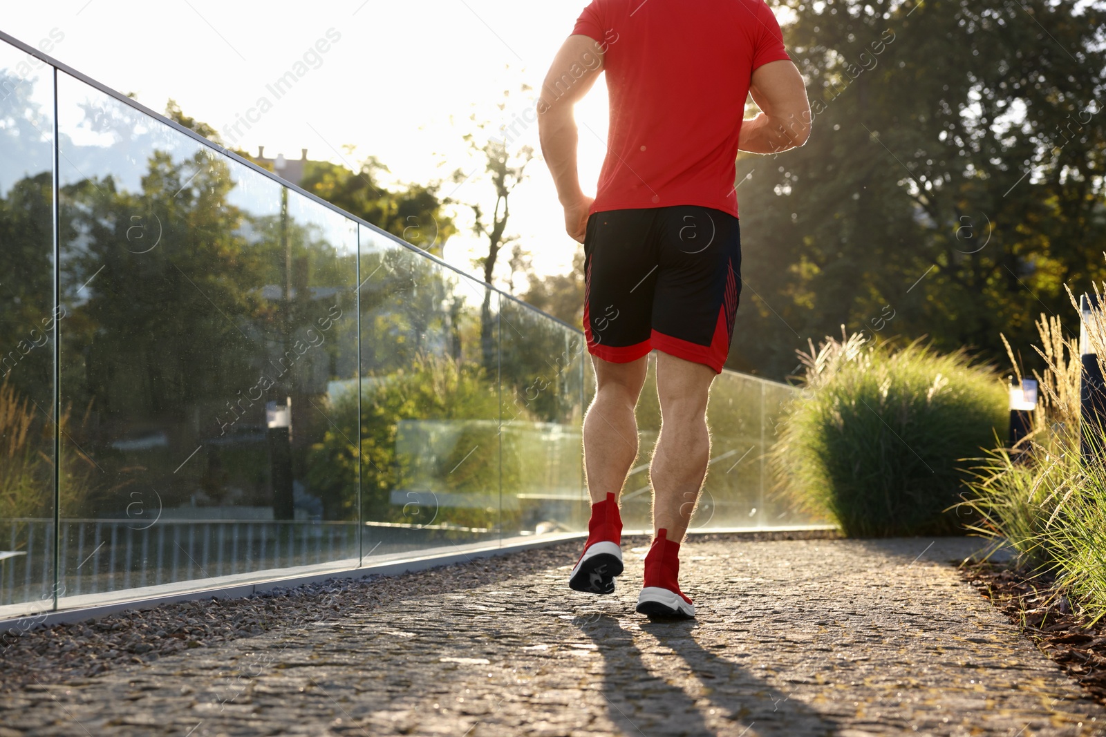 Photo of Man running outdoors on sunny day, closeup. Space for text
