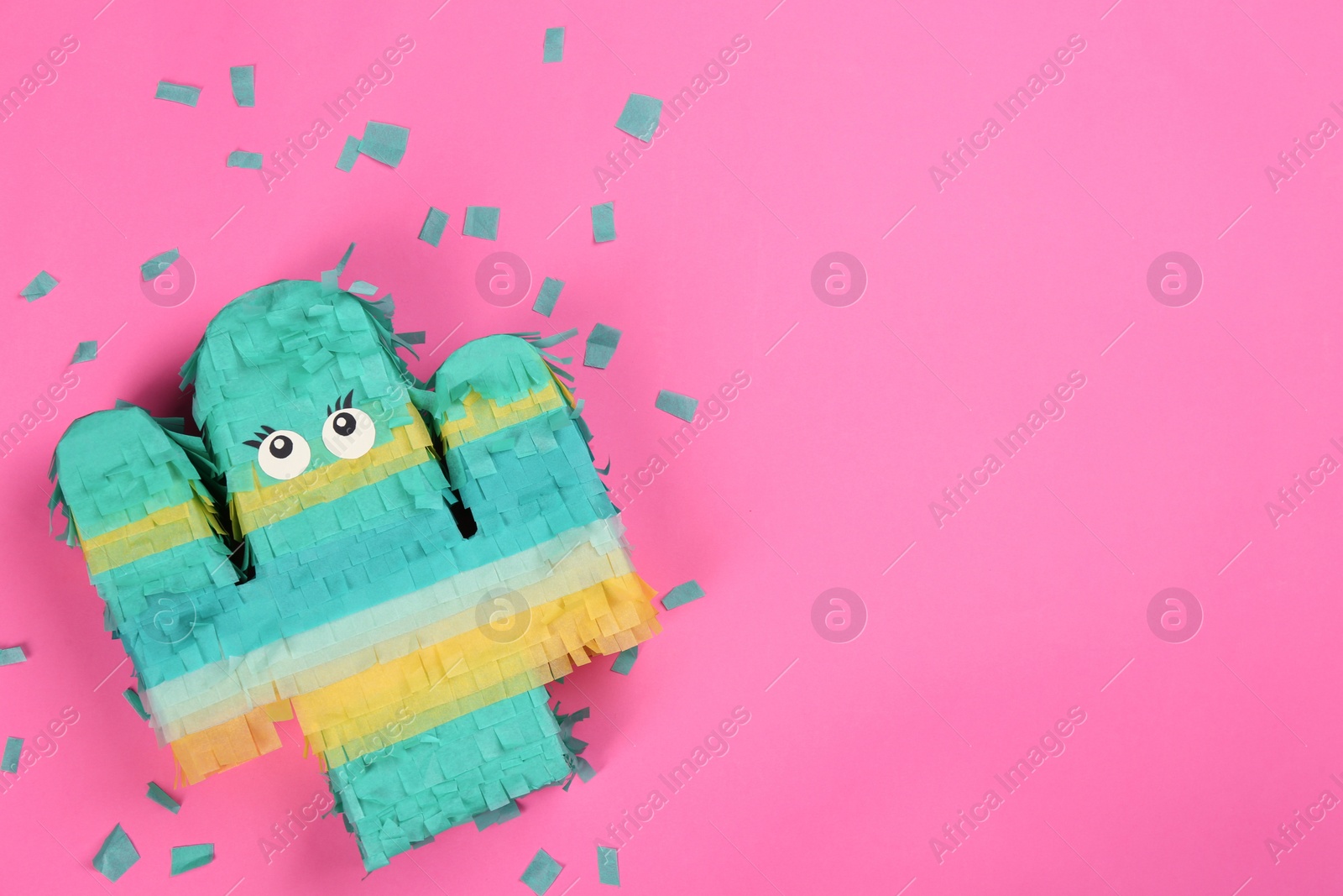 Photo of Bright cactus pinata and confetti on pink background, flat lay. Space for text