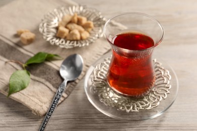 Photo of Glass of traditional Turkish tea on white wooden table, closeup. Space for text